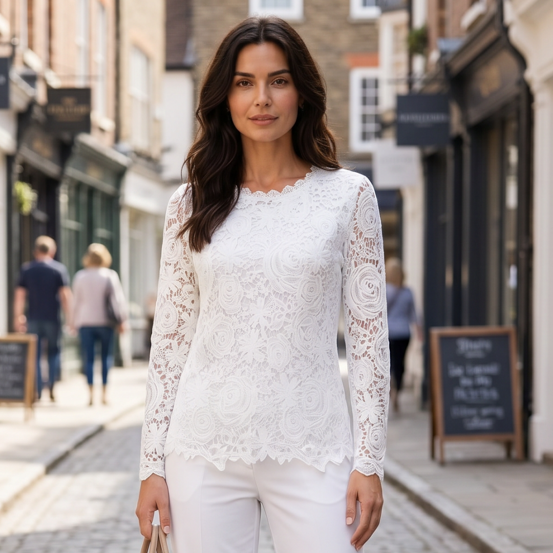 Woman wearing a white lace top and white pants on a city street.