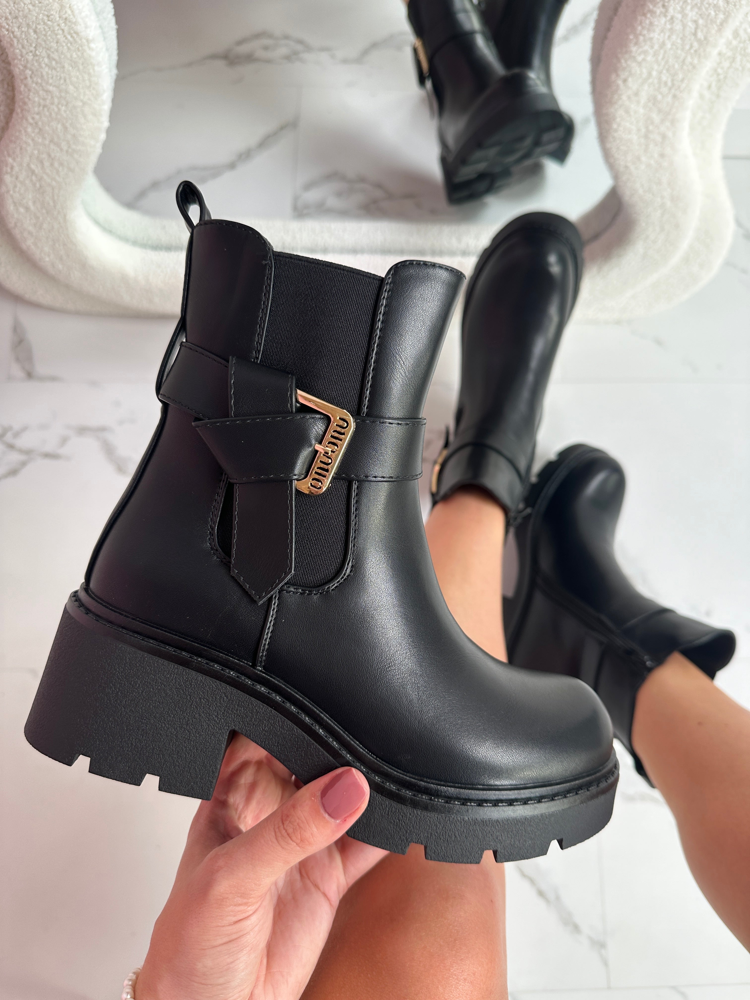 Ankle boots in synthetic leather with adjustable buckle and elevated sole