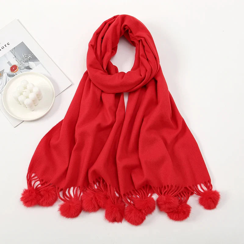 Cashmere scarf featuring pom pom detail worn loosely around neck