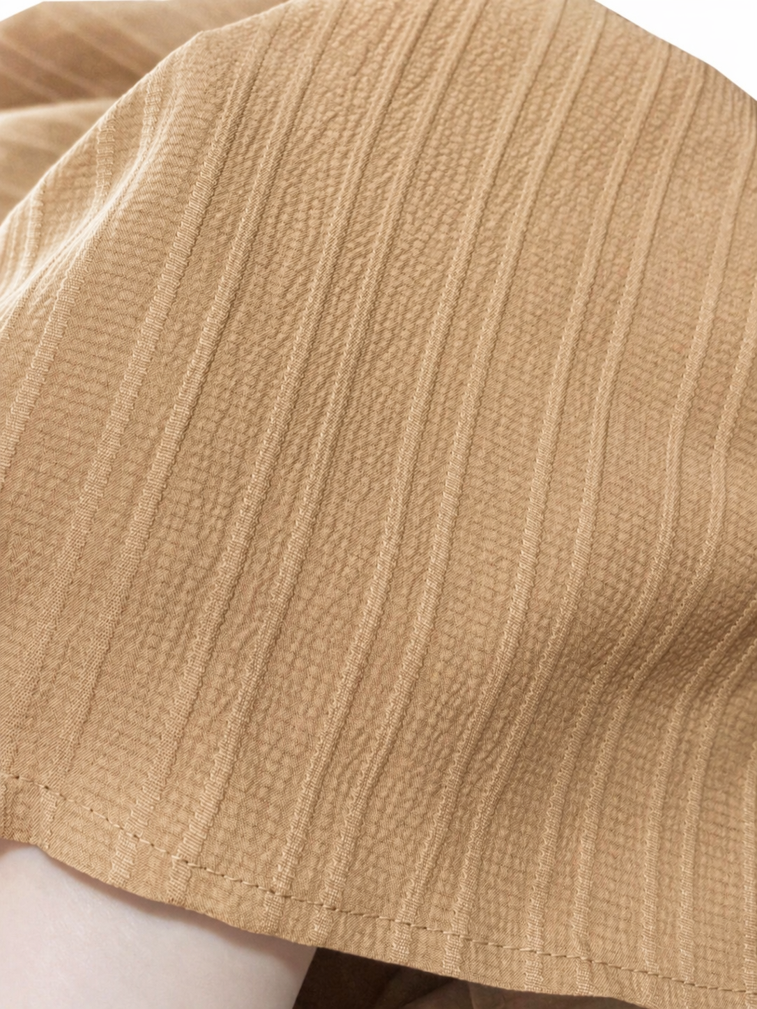Close-up detail of men's khaki summer set showing button fastening and short sleeve shirt