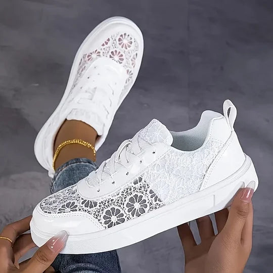 Women's white mesh sneakers with lace-up fastening, angled view showing sole and upper