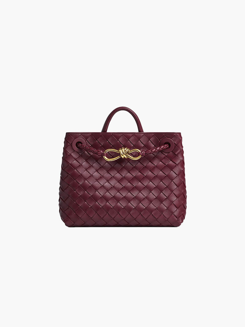 textured woven handbag with drawstring closure and gold knot detail