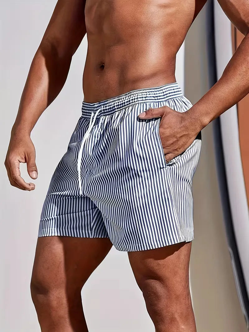 Person wearing blue and white striped swim shorts against a neutral background