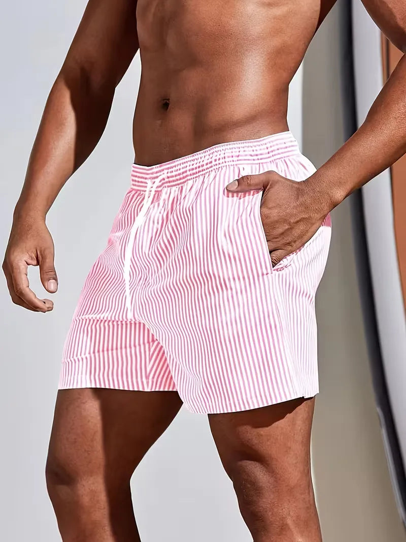 Person wearing pink and white striped swim shorts against a neutral background