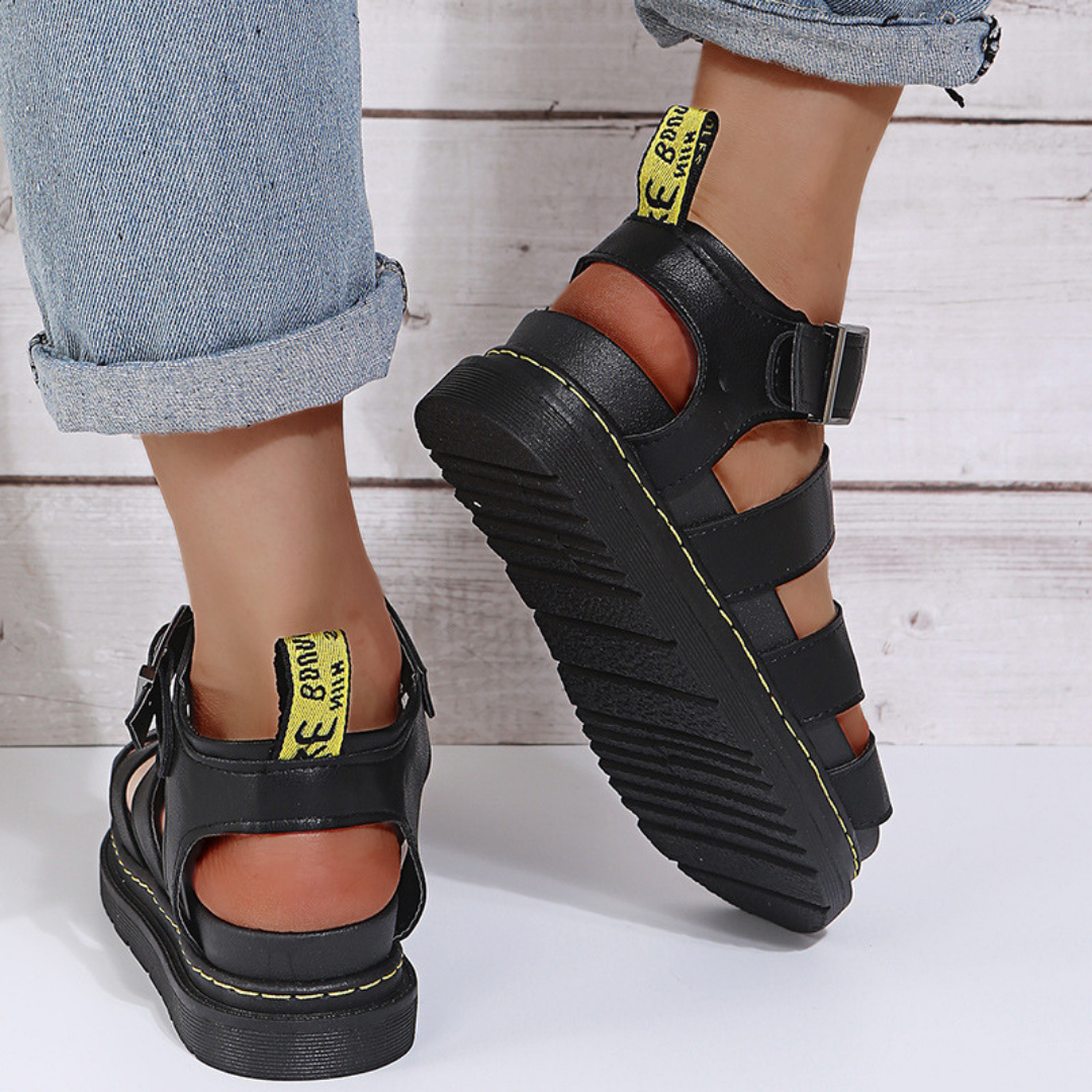 Women's red thick-sole buckle sandal with open toe, side profile showing chunky sole construction