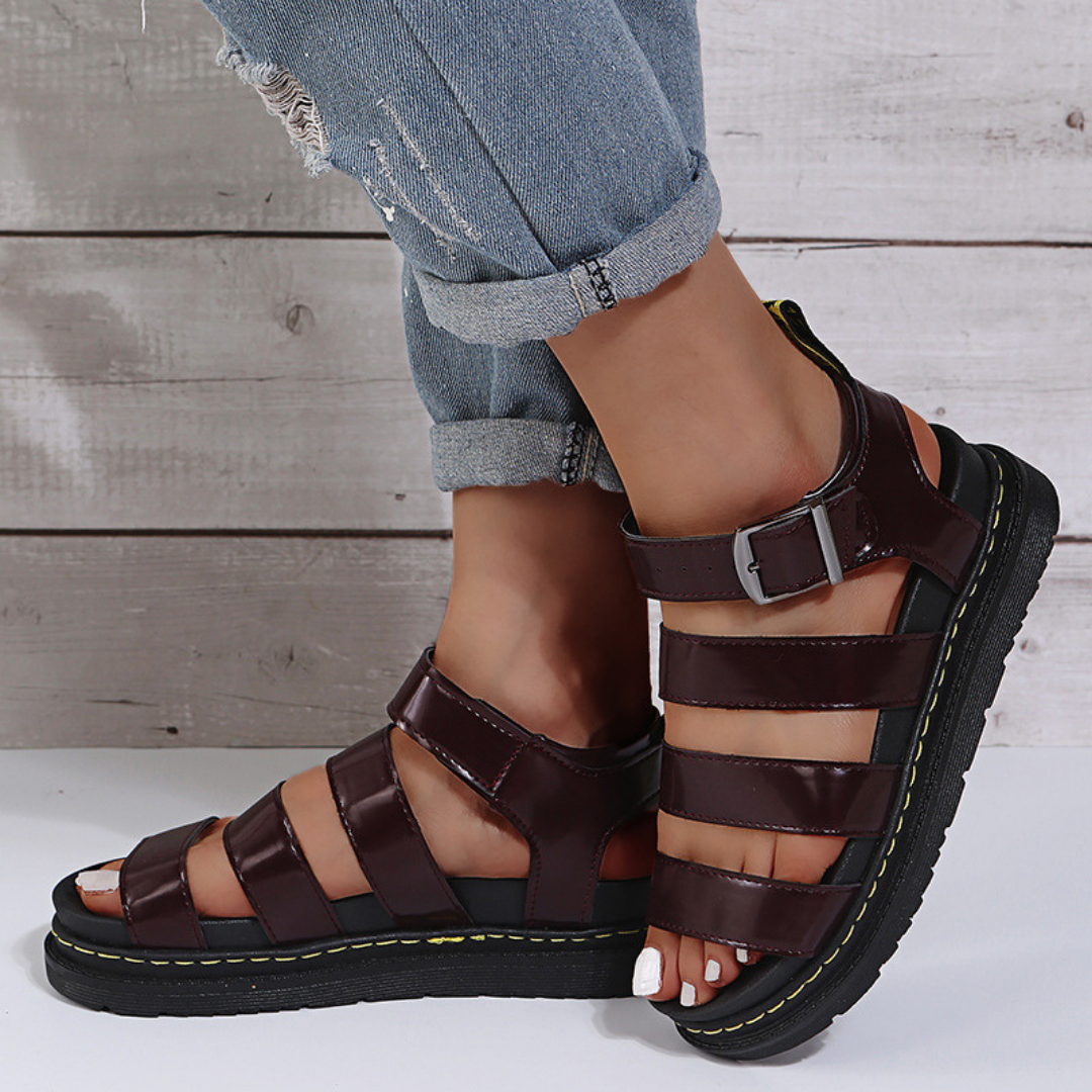 Close-up of red women's sandal buckle strap and thick sole detail