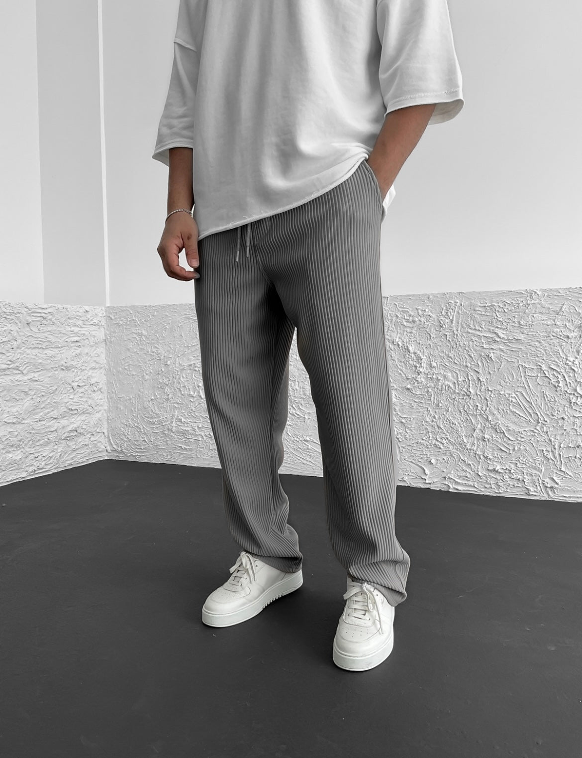 Cotton trousers photographed from side showing relaxed drape
