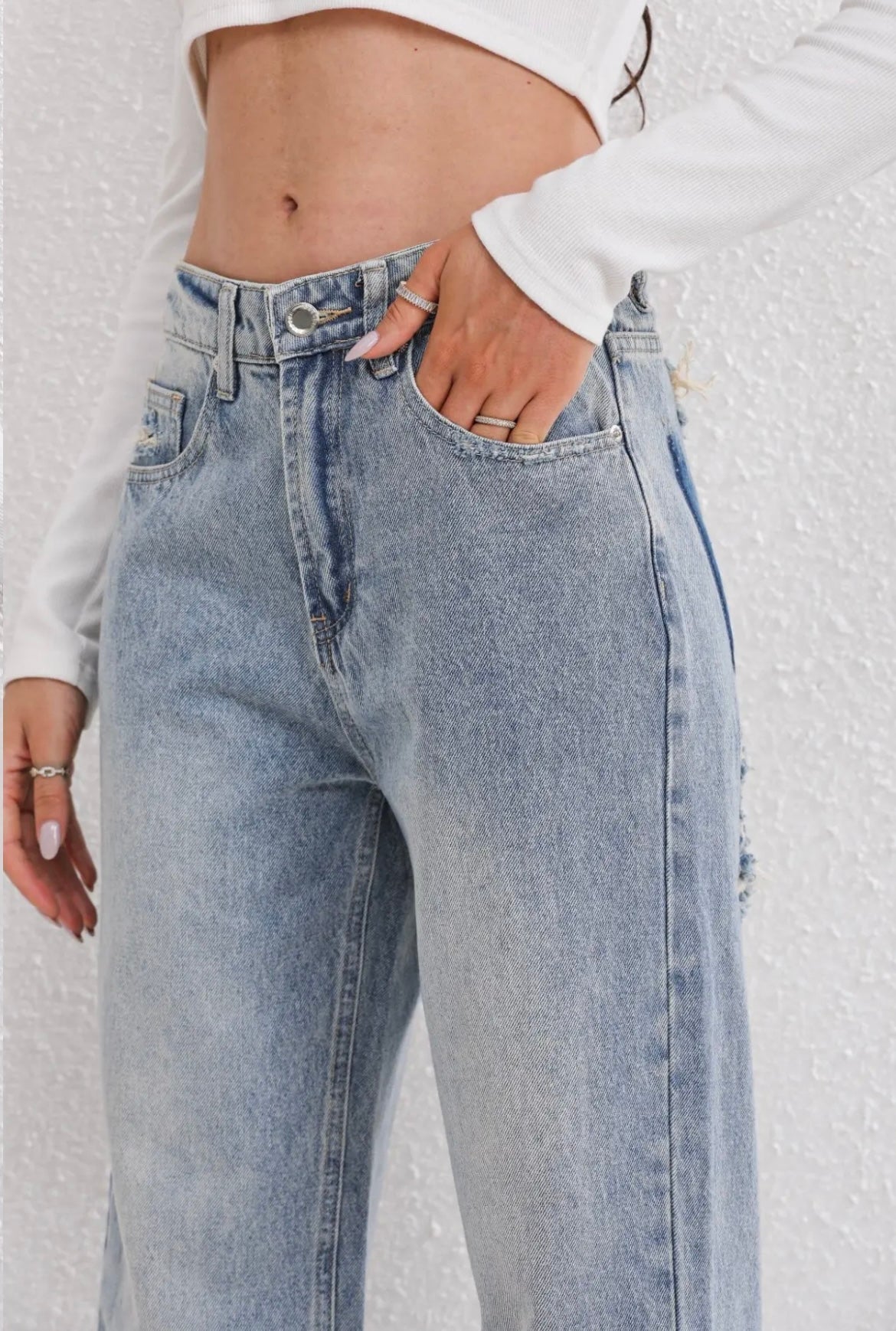 Women's blue ripped jeans with distressed detailing – close-up
