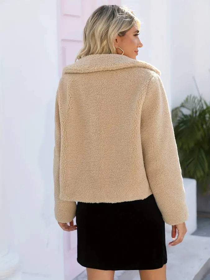 hip length winter coat in soft shearling fabric featuring front fastening detail on wearer
