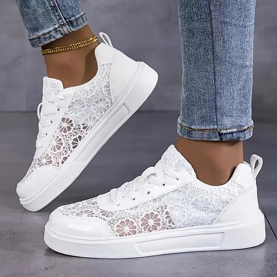 Close-up of women's white mesh sneaker upper with lace-up closur