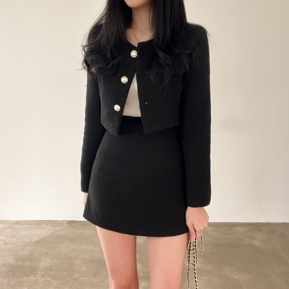 Women's black blazer and skirt two-piece set with button fastening blazer and tailored short skirt — front view