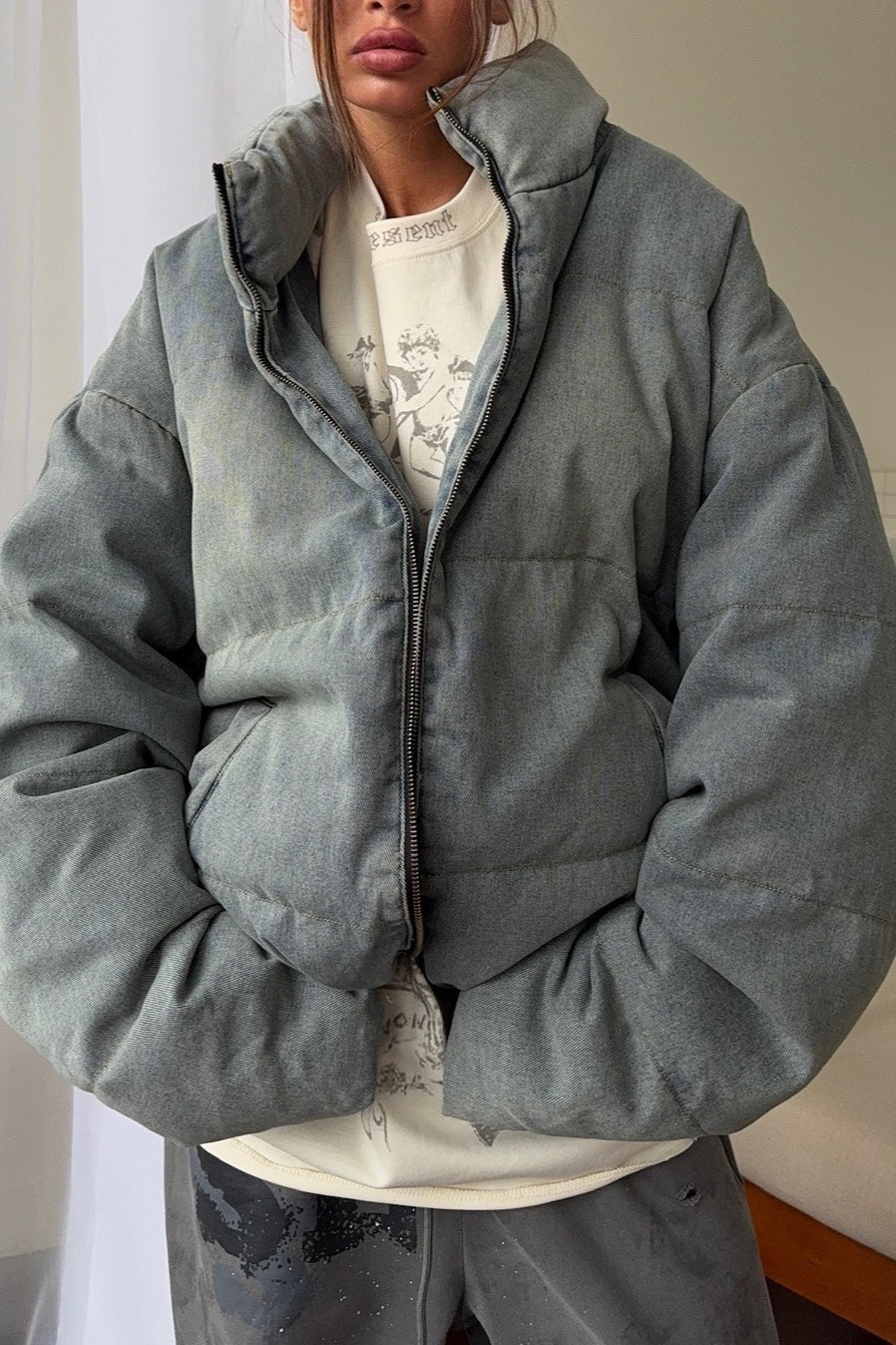 Denim puffer jacket with quilted padding worn over casual outfit